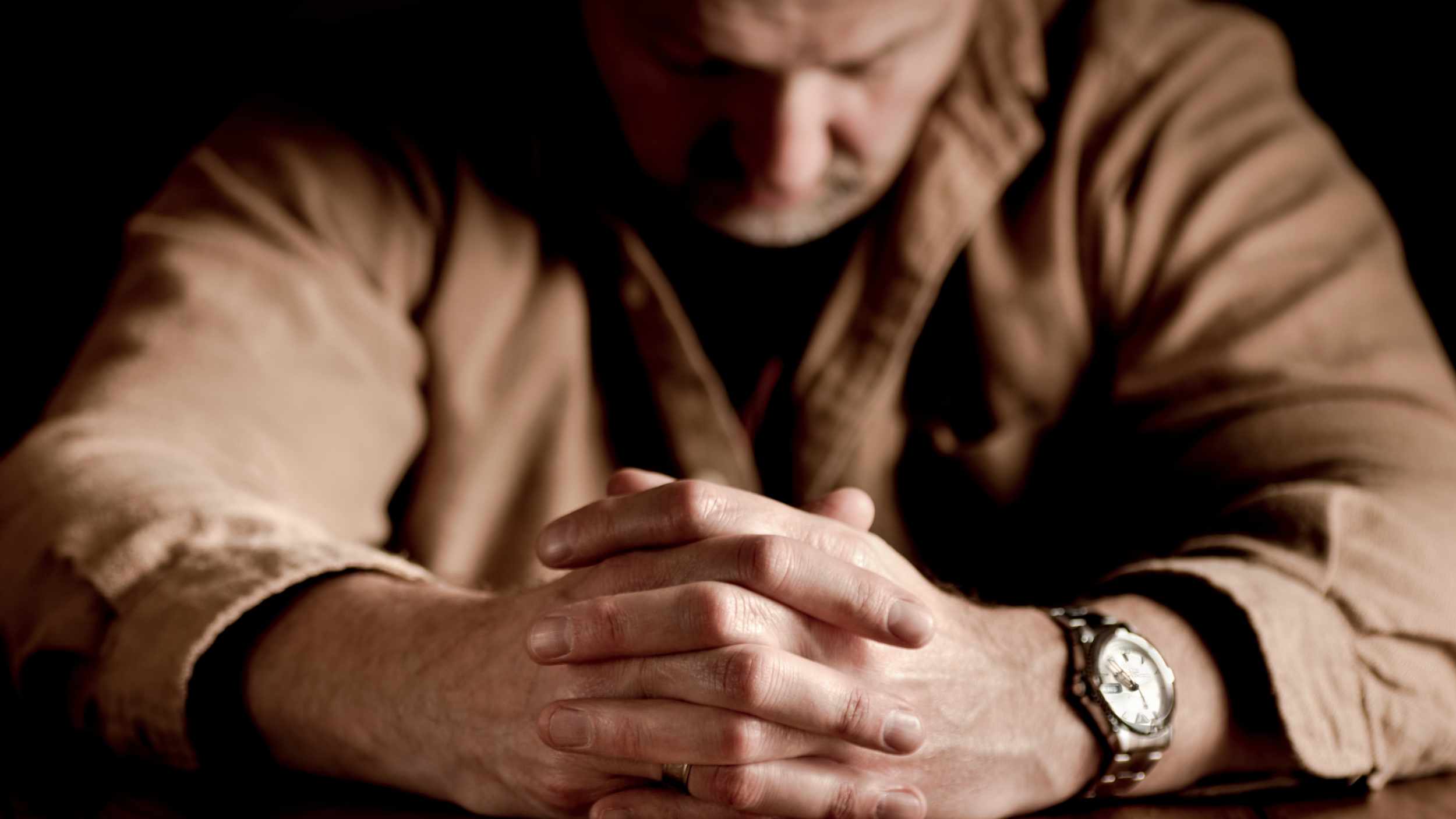 man-sad-with-grief-folding-hands-and-praying-16x9.jpg